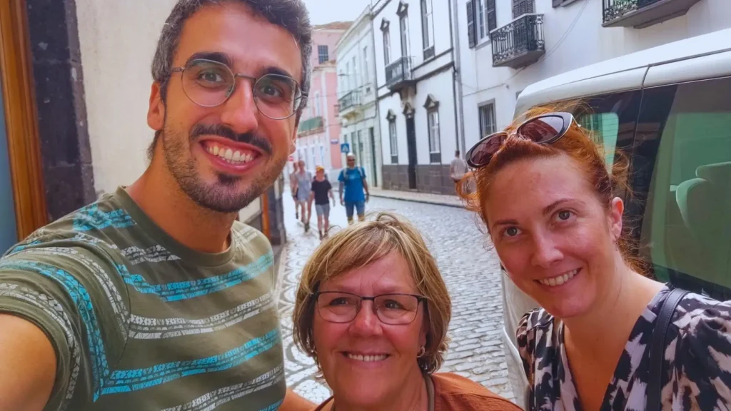 tour-groups-fr A boy and two ladies taking a selfie on the sidewalk of a cobblestone street.