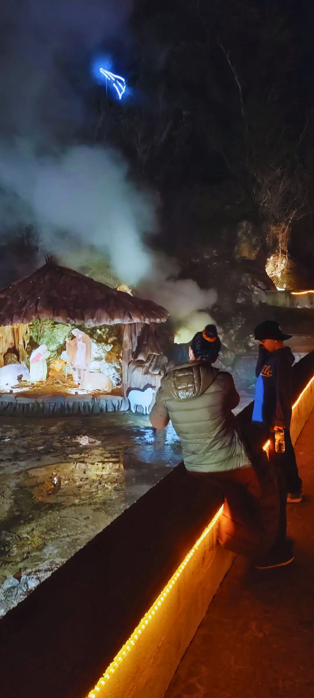 A mother with her son contemplating fumaroles, the boy covers his nose.