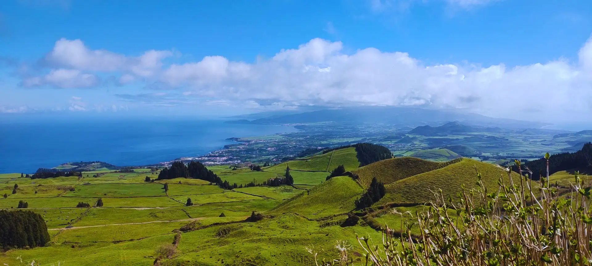 A longitudinal view of an island, hills and towns compose the center, ocean to the sides.