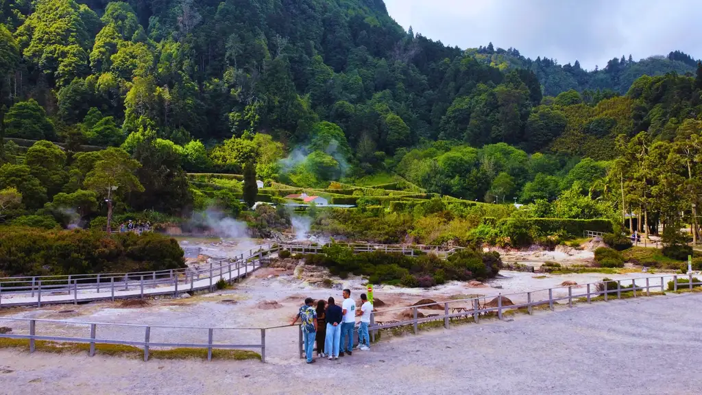 Furnas geothermal field by the Lagoon of Furnas, with lush vegetation as background.